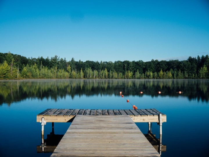 Still lake and dock at dawn