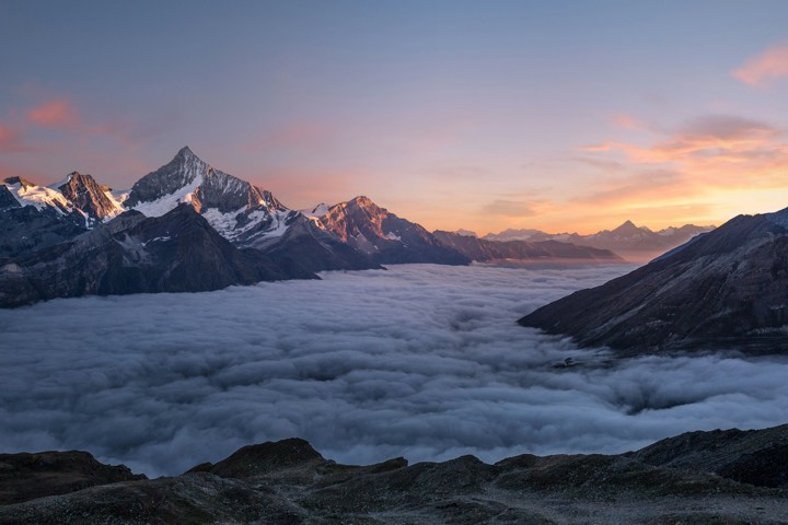 Alpine peaks over clouds at sunset